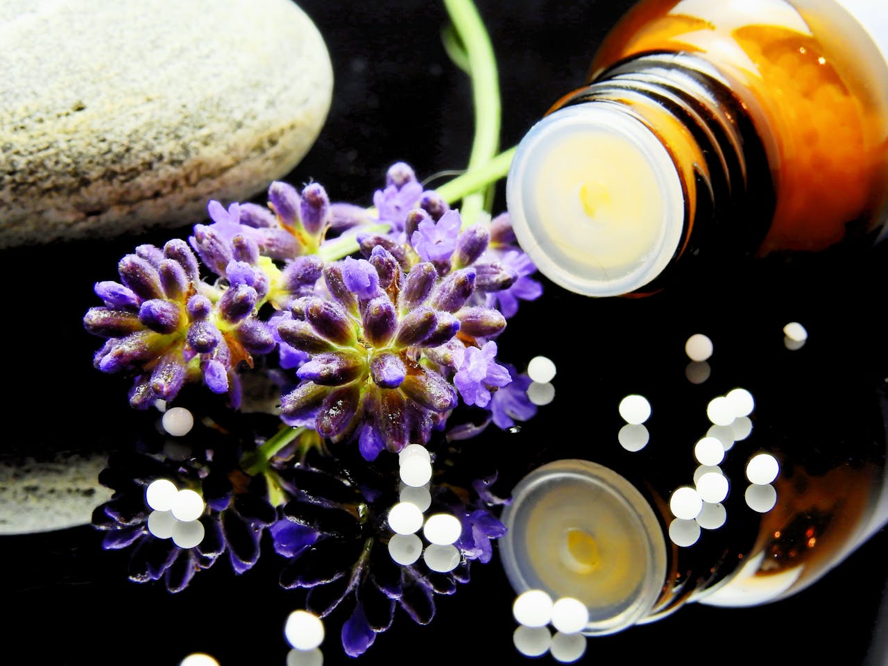gallery-5 Lavender flowers with herbal homeopathy on a reflective surface, ideal for natural therapy themes.